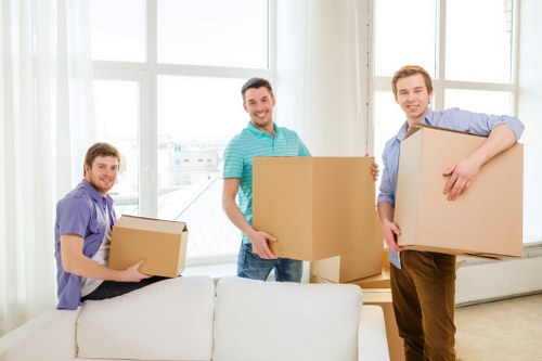 Professional movers carrying furniture through a residential building staircase
